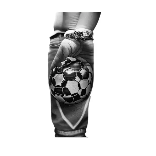 A Boy With A Soccer Ball Watch A Wall